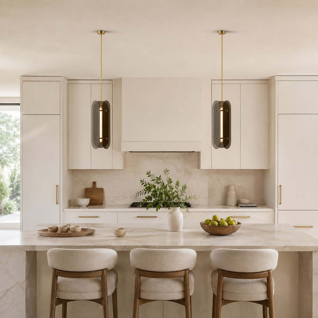 Two tall Clérachic pendants in smoke-grey glass above a cream kitchen island with upholstered wooden stools.
