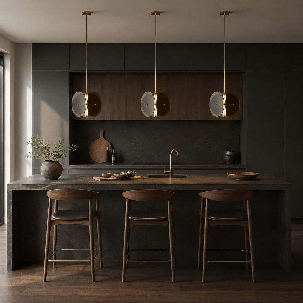 Three Clérachic smoked glass pendants above a dark kitchen island with wooden stools, against black cabinetry.