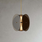 Clérachic smoked glass pendant seen from the front, two tinted discs overlapping around a lit frosted tube, on grey.