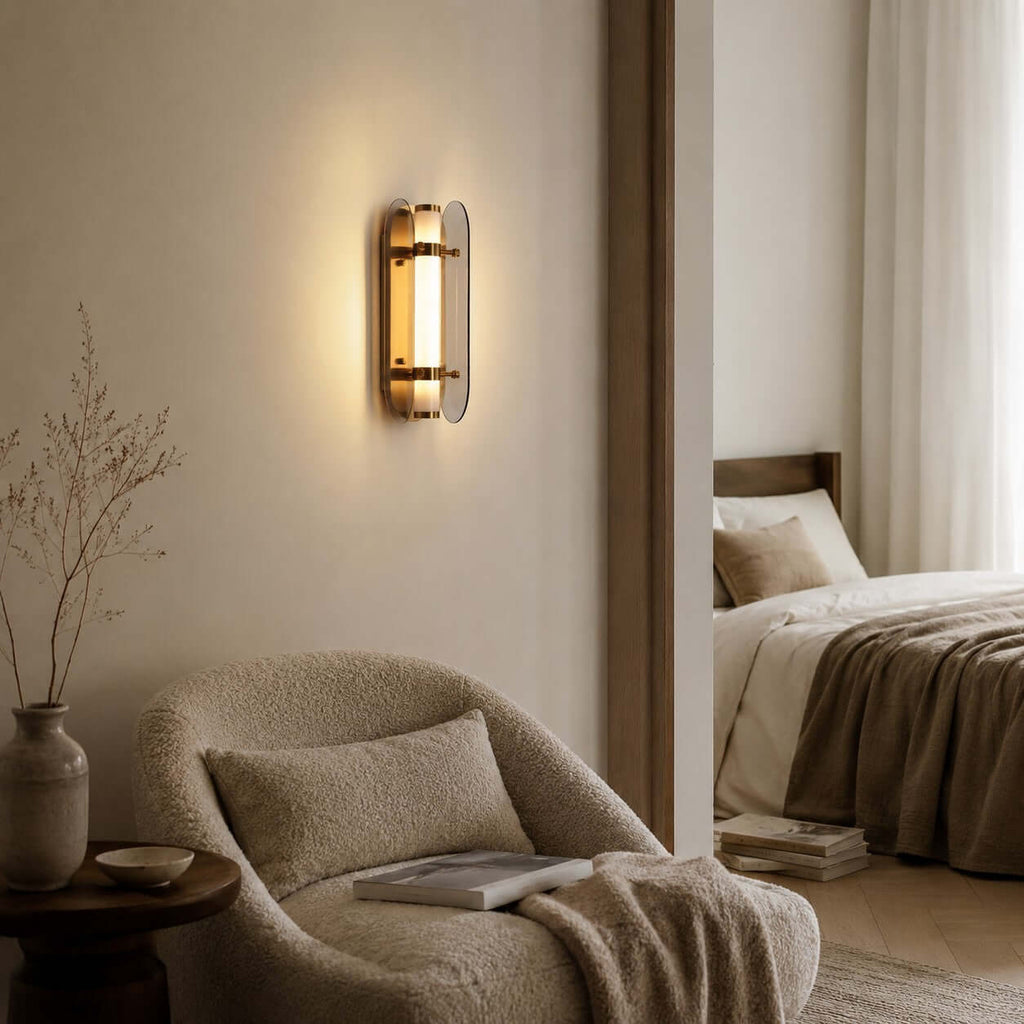 Lit Clérachic smoked-glass wall light on a taupe wall, beside a boucle armchair and a doorway into a bedroom.