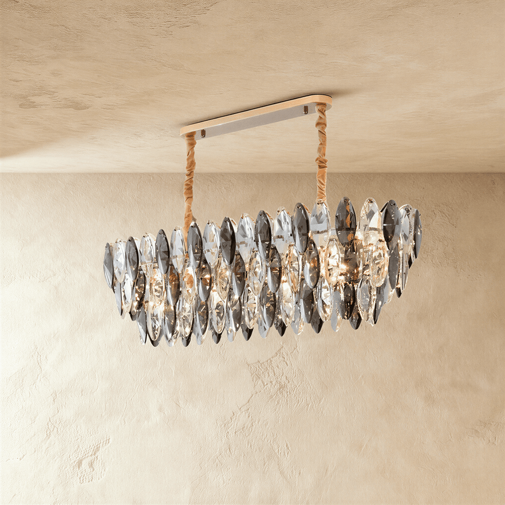 Clérachic oval chandelier of tiered smoked and clear crystal leaves, hung from a gold bar canopy on wrapped cords, against limewash.