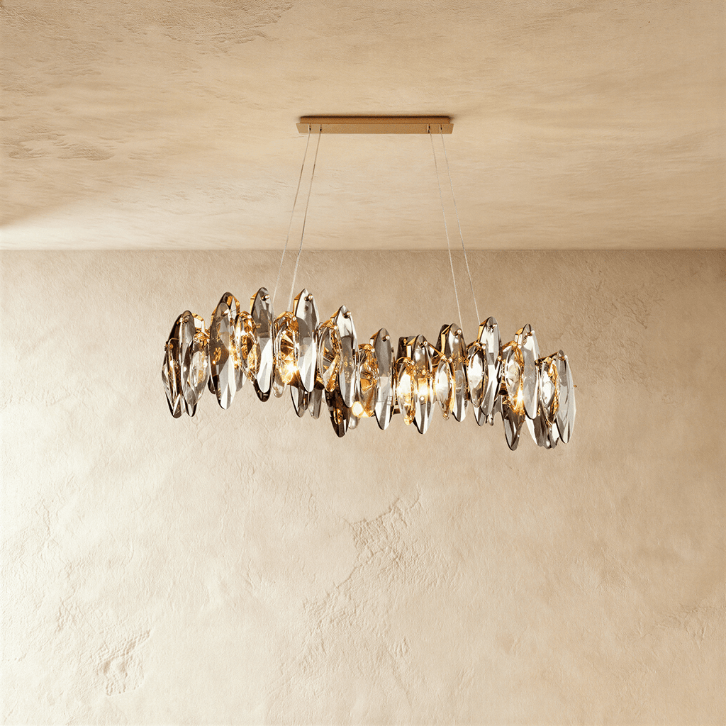 Clérachic long wave-shaped chandelier of smoked crystal leaves on fine wires from a slim gold bar canopy, against limewash plaster.