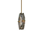 Smaller view of the Clérachic crystal pendant on white, its two brass-pinned panels and a faint bulb glow seen at an angle.
