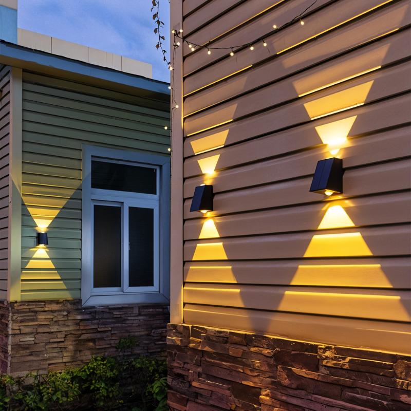 Clérachic black solar wall lamps on cedar-style cladding beside a window, throwing warm triangular beams up and down at dusk.