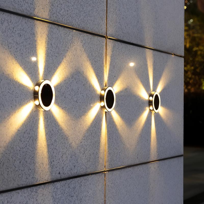 Clérachic round solar lights on a speckled stone wall at dusk, each throwing warm beams in a zigzag pattern.
