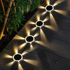 Clérachic round solar lights lined along a dark decked path beside bamboo, glowing warm white at night.