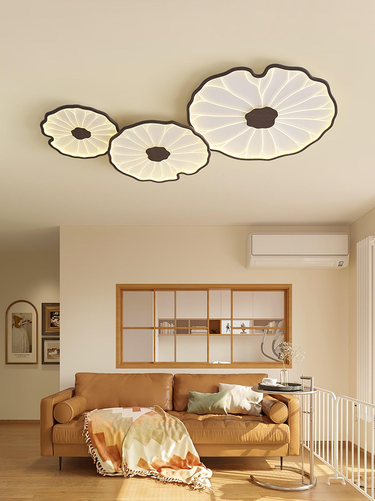 Clérachic three-shade ceiling light in dark walnut finish above a living room with a cognac leather sofa.