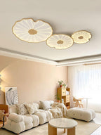 The Clérachic three-shade light in light wood-grain finish above a cream sofa and terracotta accent wall.
