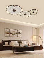 Clérachic three-shade ceiling light in dark walnut finish above a dark wood sofa and framed landscape art.