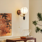Clérachic globe wall light with a floral-printed shade, lit beside a vintage record player on a wooden cabinet and a leafy painting.