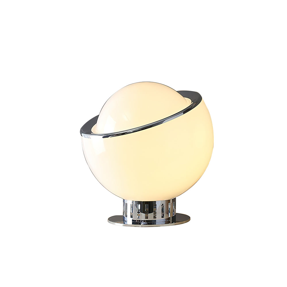 The smaller white version of this Clérachic table lamp, lit warm cream, with a tilted chrome rim and a ribbed chrome foot.