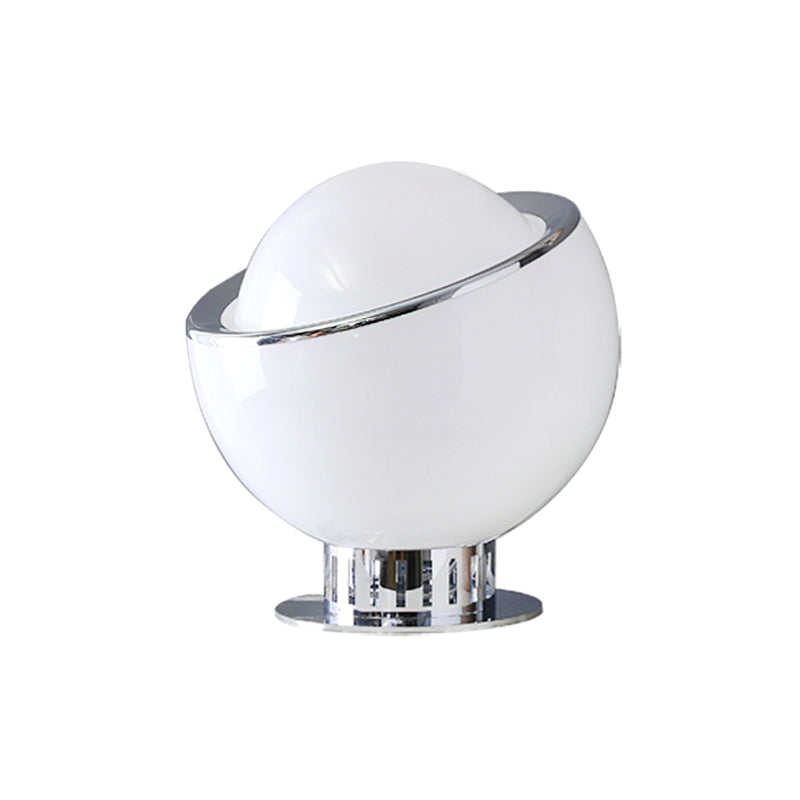 Unlit white glass body with a white dome, a thin chrome rim and a chrome base, shown as the white finish of this Clérachic table lamp.