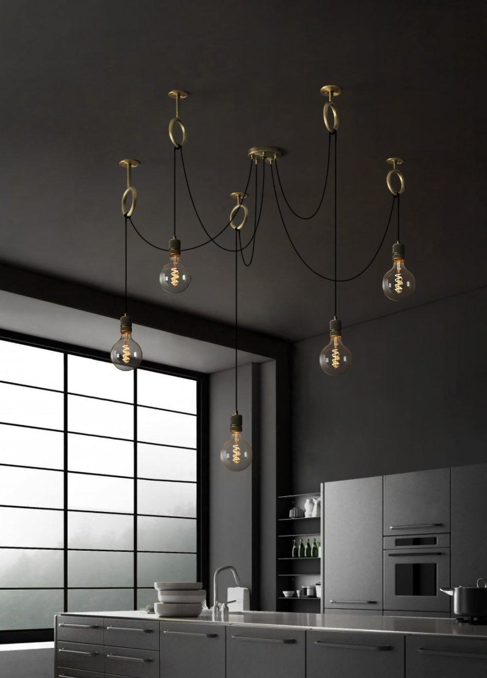 Against a charcoal wall in a dark kitchen with a large black-framed window, this Clérachic pendant hangs five globe bulbs at varied heights.
