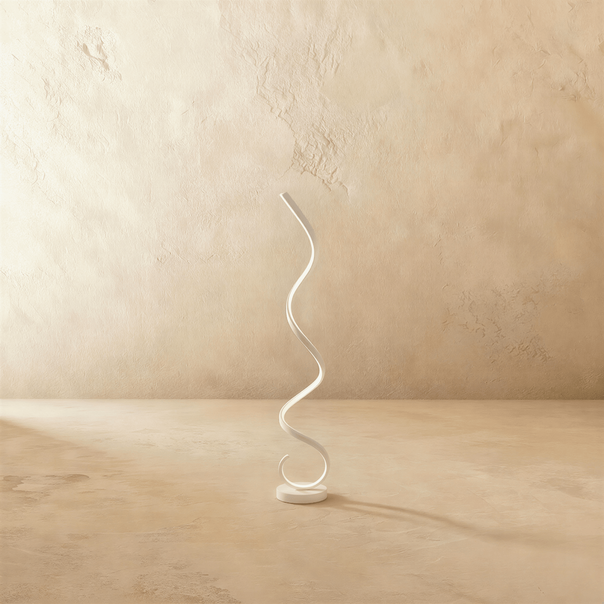 Clérachic white spiral LED floor lamp, a single ribbon curling up from a round base, on a limewash floor and wall.