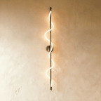 Clérachic slim vertical wall light in a brushed silver-nickel tone, a glowing spiral LED strip winding round its rod.