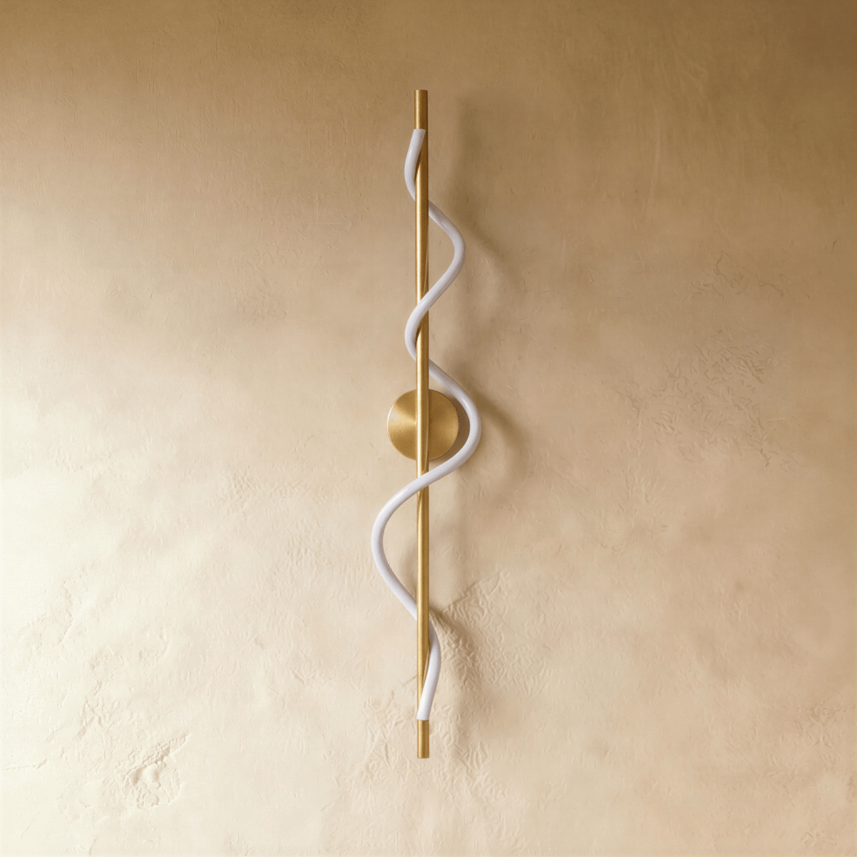 Clérachic brass vertical wall light with a round backplate and an unlit white spiral silicone strip, on a golden limewash wall.