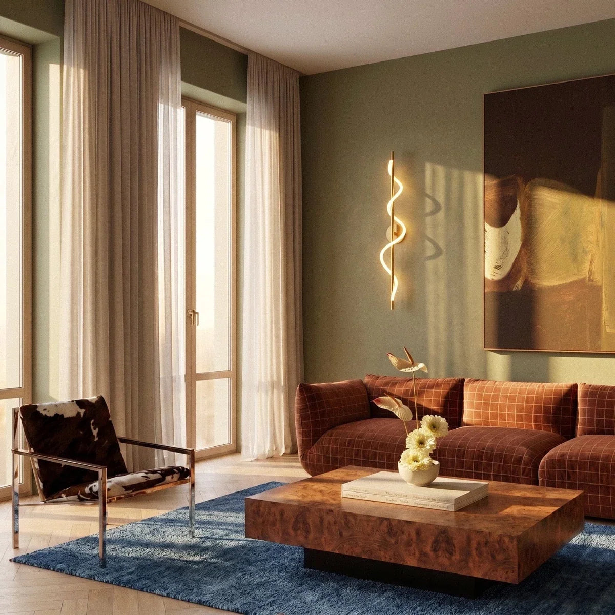 Clérachic brass spiral LED wall light in a living room with sage walls, a rust sofa, burr-wood table and tall sheer curtains.