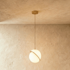 Clérachic opal white sphere pendant, a bigger size, with its brass-finish ring slicing the globe on a brass rod.