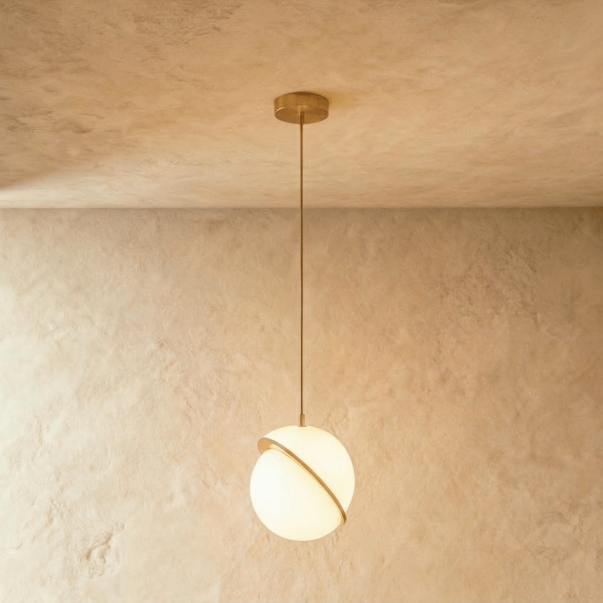 Clérachic opal white sphere pendant, a bigger size, with its brass-finish ring slicing the globe on a brass rod.