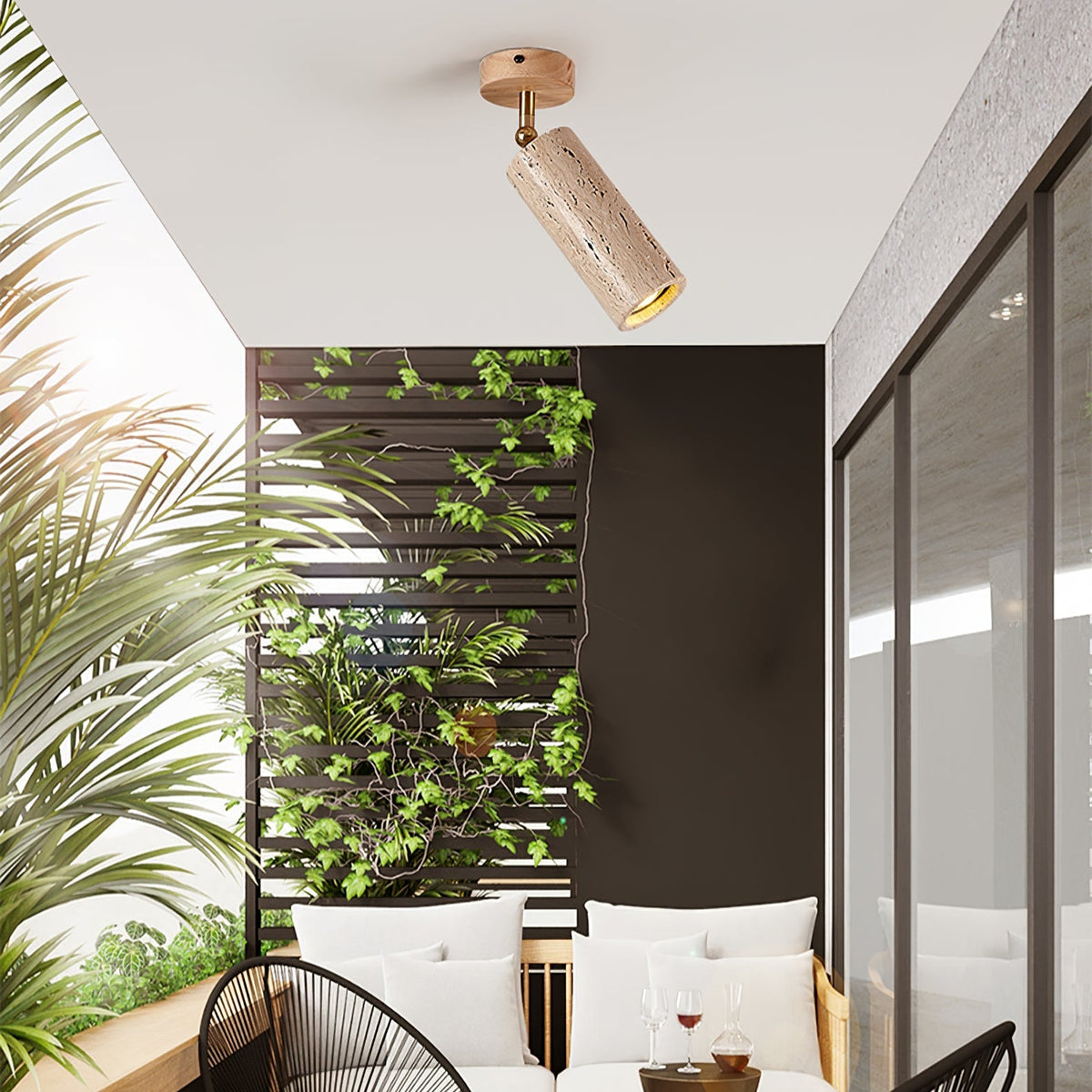 Clérachic travertine spotlight with a pale wood canopy on a white ceiling over a balcony seating area with green climbing plants.