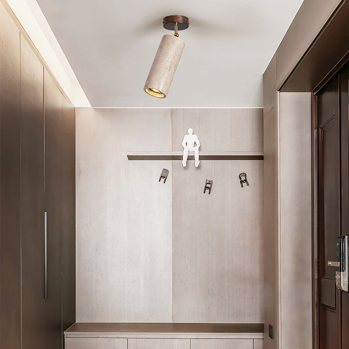 Clérachic travertine spotlight on the ceiling of an entrance hall, with a pale stone wall, wall hooks and wooden cabinets on both sides.