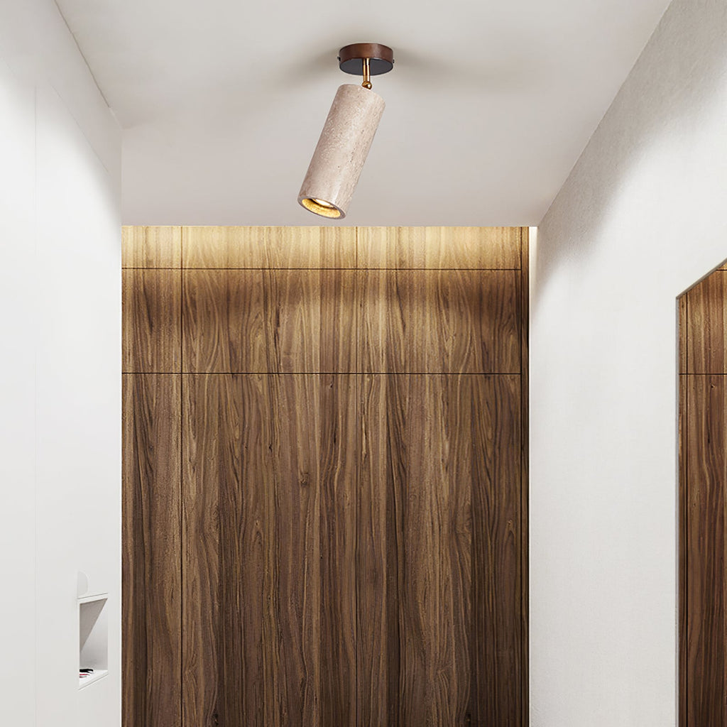 Clérachic travertine cylinder spotlight on a white ceiling above a walnut wall panel, in a hall with a recessed niche.