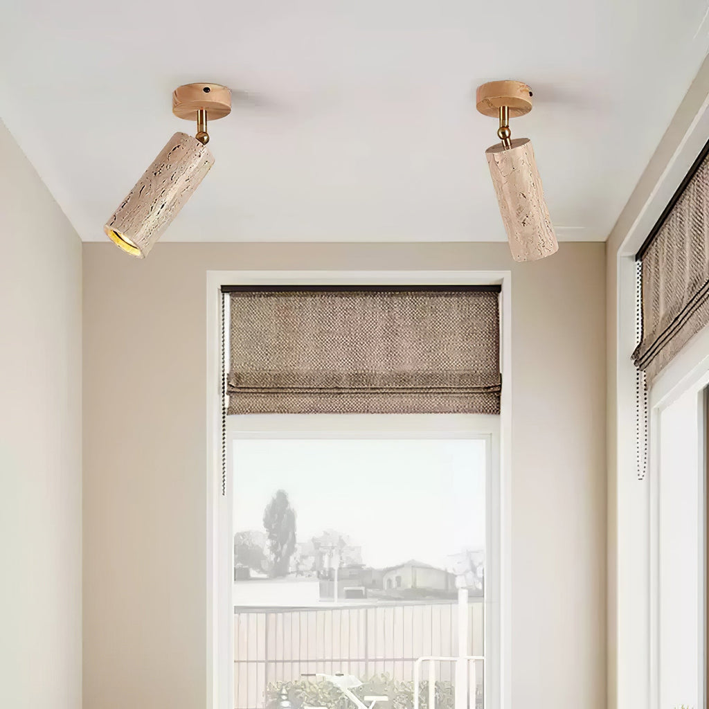 Pair of Clérachic travertine spotlights on a white ceiling, pivoted to face different ways above a window with a woven blind.