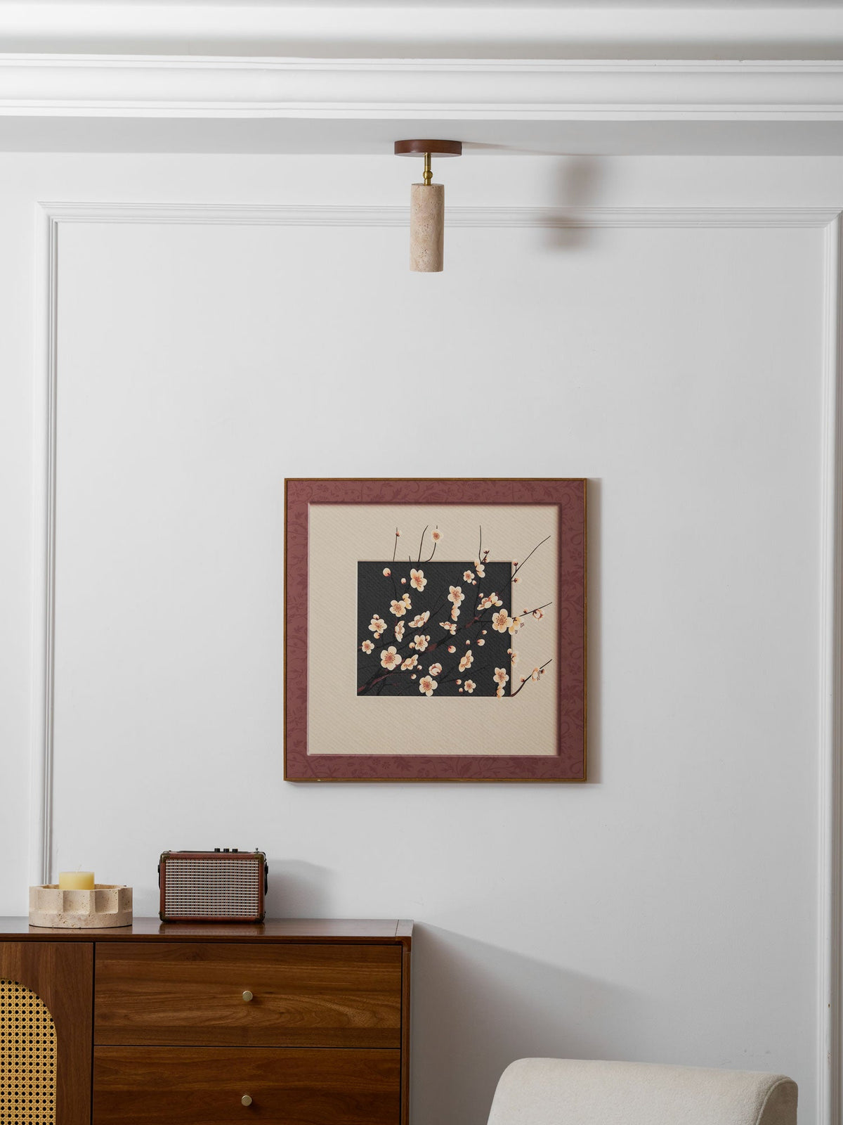 Unlit Clérachic spotlight on a ceiling above a framed blossom print on a white panelled wall, with a walnut chest below.