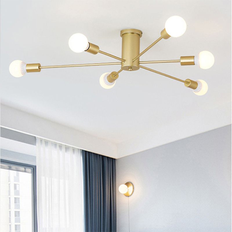 This gold Clérachic Sputnik Globe Ceiling Light lights a living room corner, with a wall sconce glowing below it.