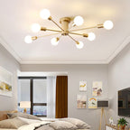 The gold Clérachic Sputnik Globe Ceiling Light glows warm above a bedroom ceiling trimmed with crown molding.