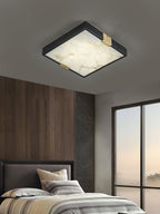 Clérachic Square Alabaster Flush Mount Ceiling Light lit over a bed set against a walnut panelled wall, its black frame reading as one thin square edge.