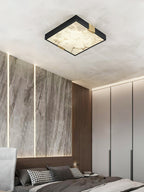 Clérachic Square Alabaster Flush Mount Ceiling Light lit beside built-in wardrobes, its brass corner saddles catching the light against the black frame.