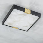 Close-up of the Clérachic Square Alabaster Flush Mount Ceiling Light unlit, showing the brushed brass saddle that clamps the stone to the black frame.