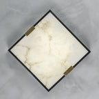 Clérachic Square Alabaster Flush Mount Ceiling Light shown face-on and turned to a diamond, brass saddles gripping two opposite corners of the frame.