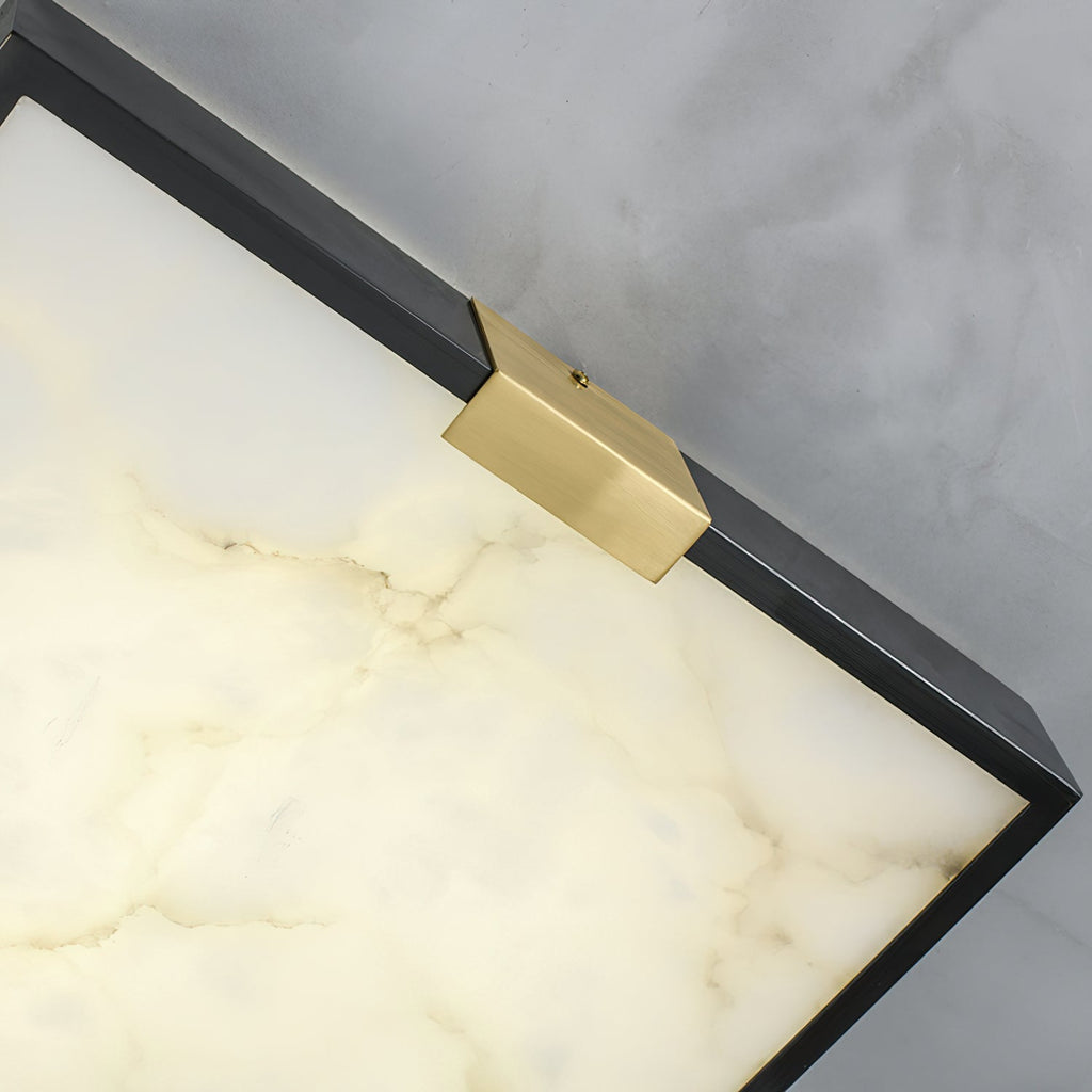 Corner detail of the Clérachic Square Alabaster Flush Mount Ceiling Light, the alabaster faintly lit so fine veining shows beneath the brass saddle.