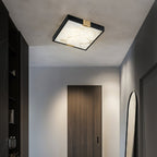 Clérachic Square Alabaster Flush Mount Ceiling Light lighting a narrow hallway ceiling, a warm square of stone above a dark timber door.