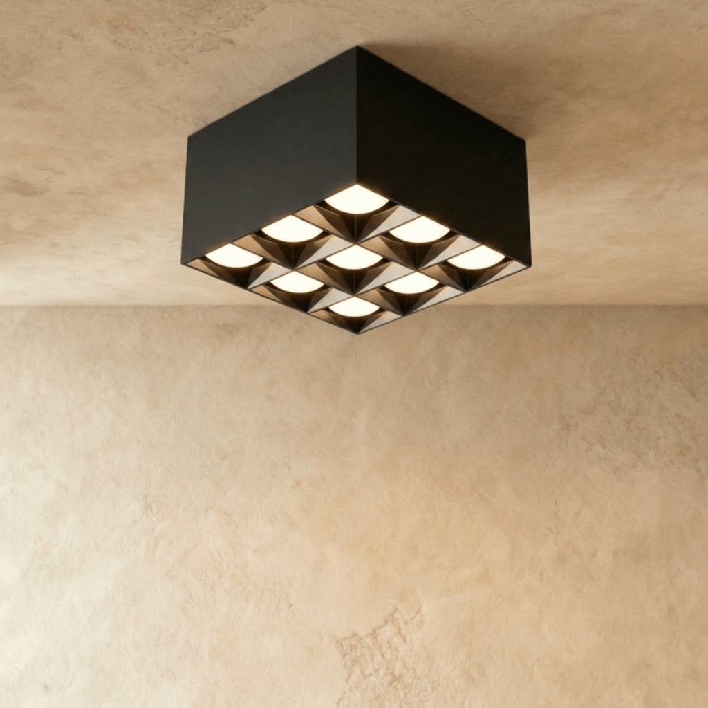 Clérachic black square box ceiling downlight with nine lit spot cells in a three by three grid, studio shot on limewash.