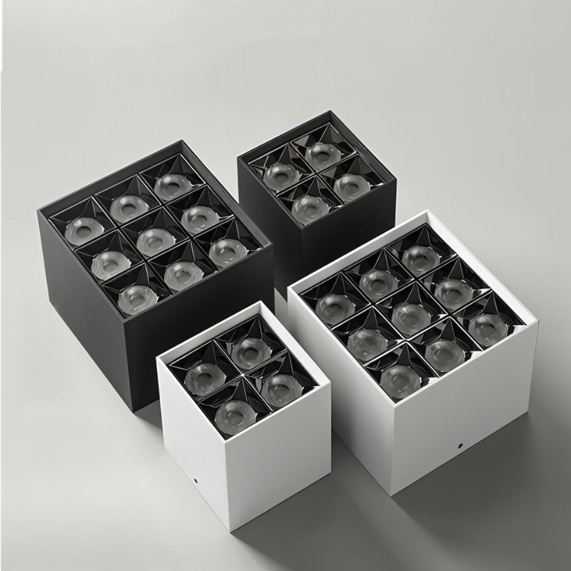 Studio view from below of black and white Clérachic square box downlights in four-cell and nine-cell sizes on a grey backdrop.