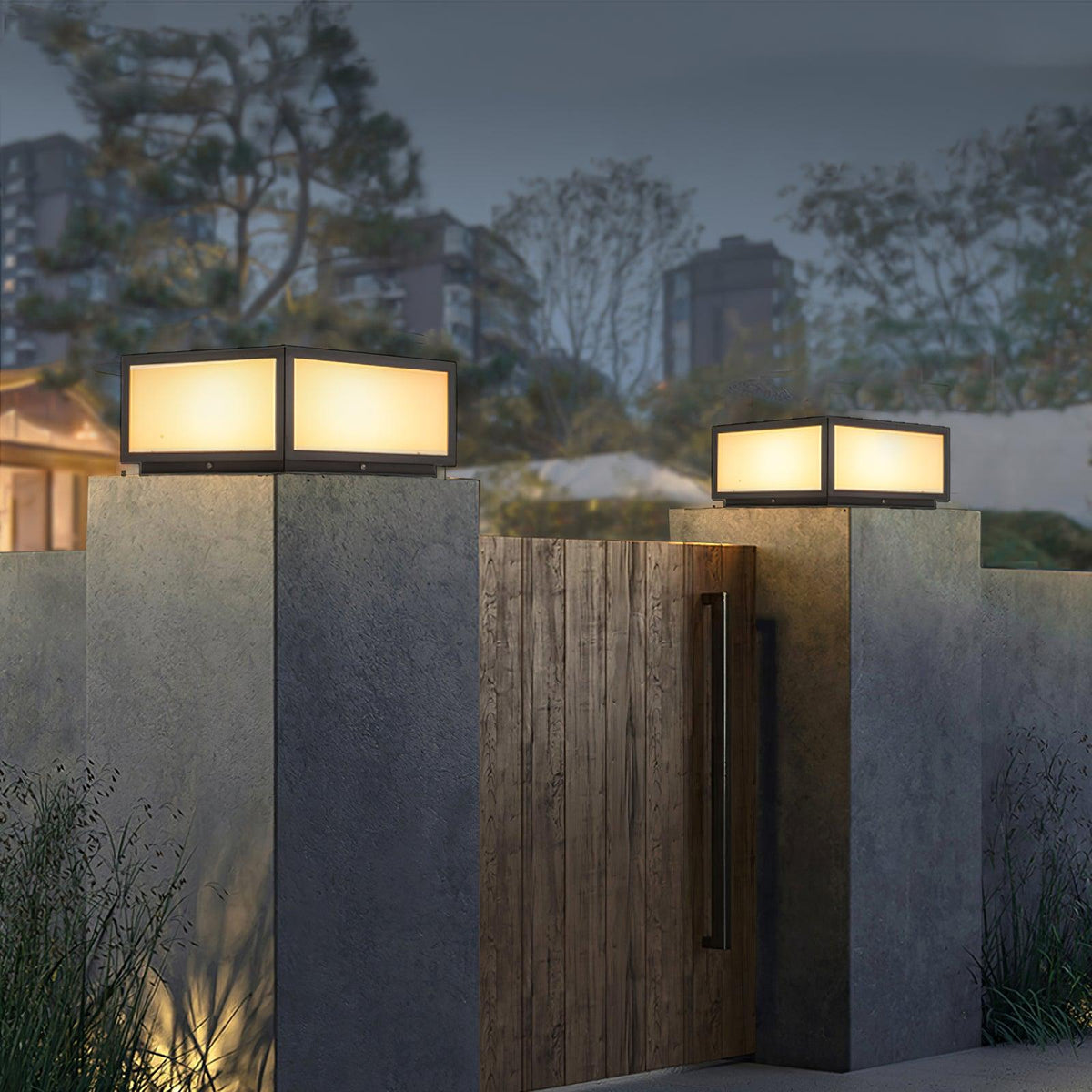 Clérachic post lights glowing on grey concrete pillars either side of a timber gate, with city lights in the distance.