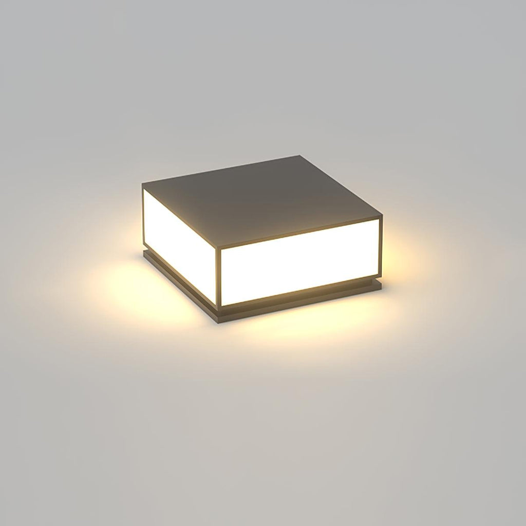 Square black Clérachic post light with a solid flat top, lit with a warm glow on a plain grey background.
