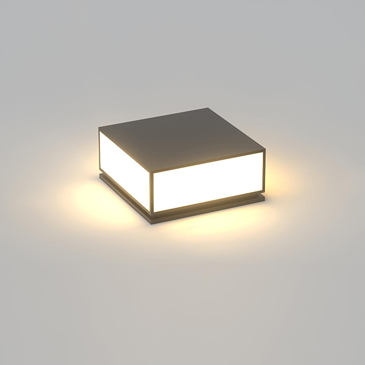 Square black Clérachic post light with a solid flat top, lit with a warm glow on a plain grey background.