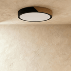 Clérachic round flush ceiling light in black and wood, switched off, its flat white diffuser sitting just inside the black rim.