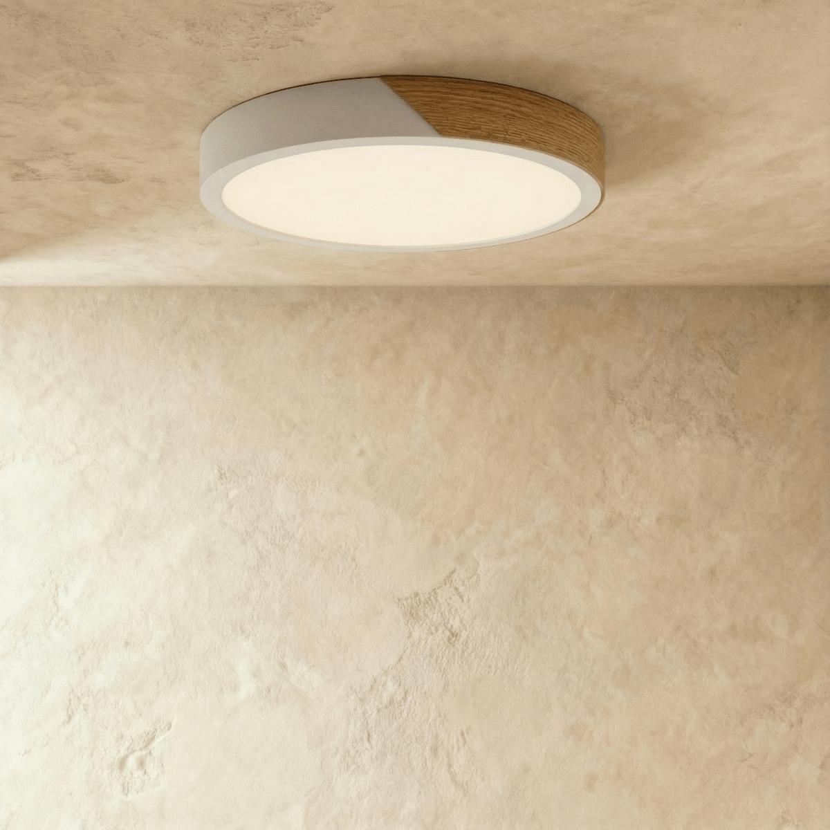 Clérachic round flush ceiling light in white and wood, lit warm so the pale rim almost disappears into the plaster ceiling.