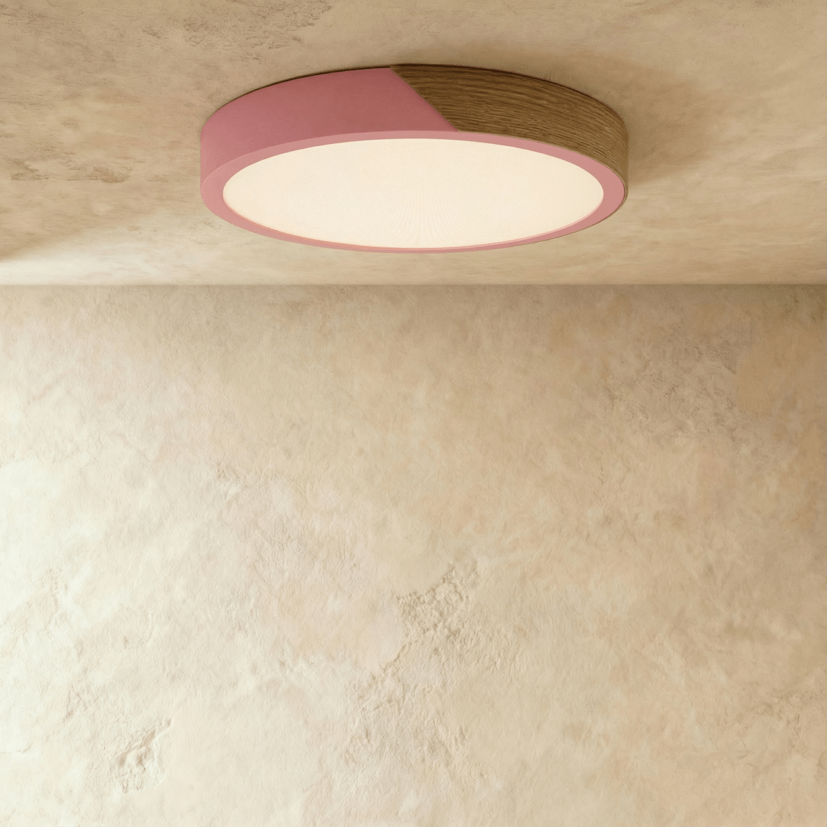 Clérachic round flush ceiling light in dusty pink and wood, its diffuser lit warm beneath the two-tone band.