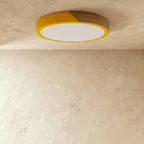 Clérachic round flush ceiling light in golden yellow and wood, unlit, the wood grain running the length of the band.