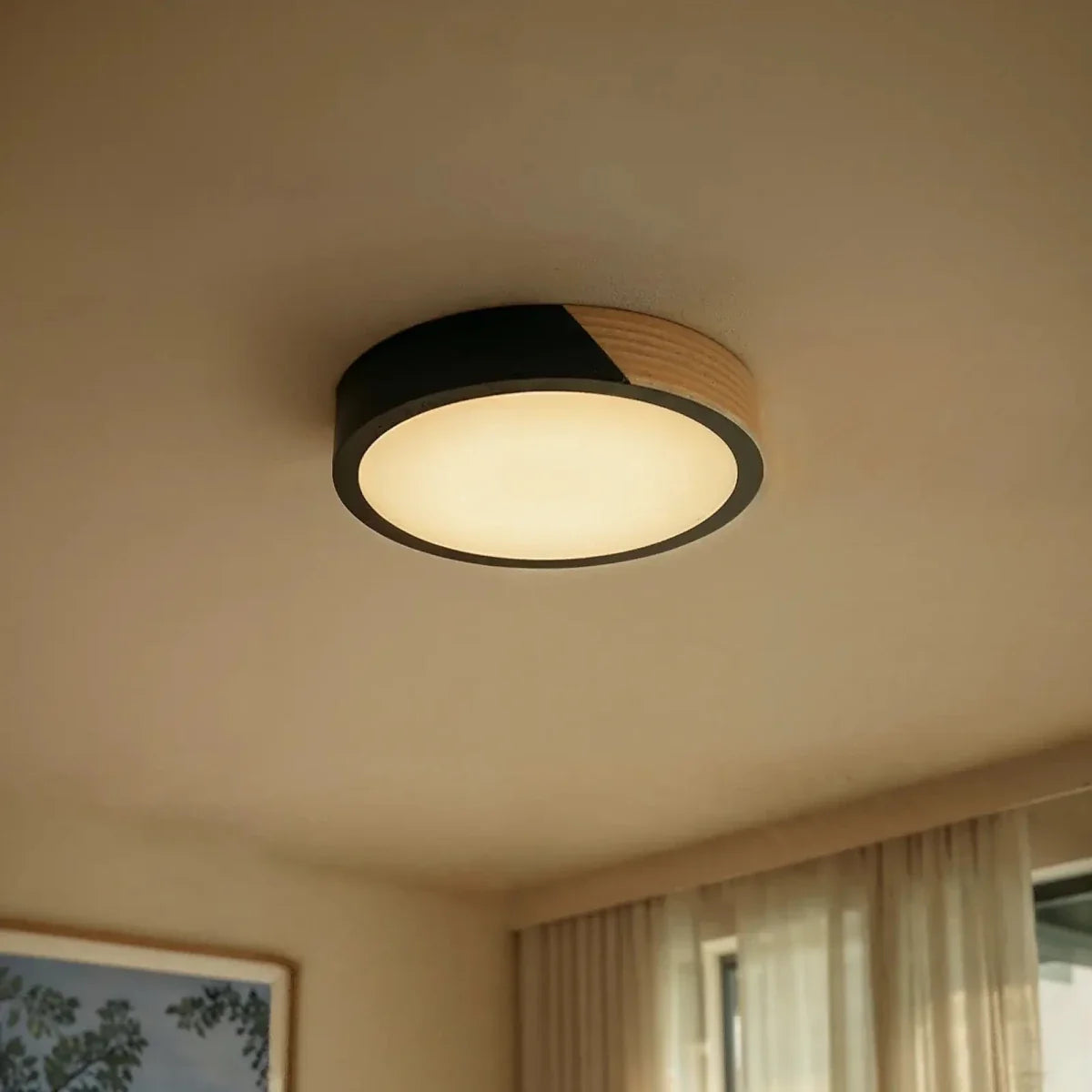 Clérachic round flush ceiling light in black and wood, glowing warm in a curtained room at dusk.