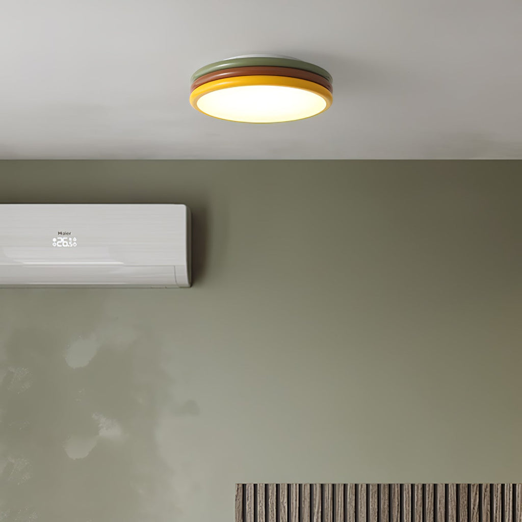 Clérachic ceiling light lit above a sage-green wall with a wall-mounted air conditioner and a slatted panel.