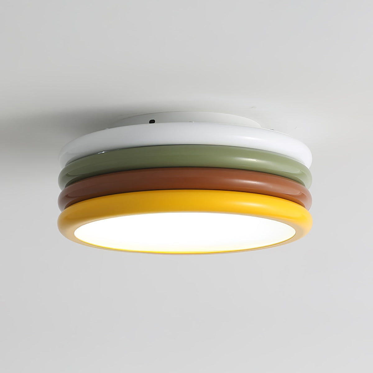 Angled view of this Clérachic ceiling light lit on a light grey ceiling, the white ring on top and a yellow rim below.