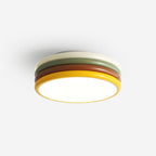 Clérachic ceiling light lit against a white backdrop, shown from below with its white top ring and yellow edge around the glow.