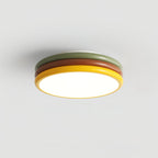 Simple side view of this Clérachic ceiling light on a grey backdrop, with green, red-brown and yellow tiers and the diffuser lit.